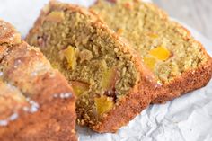 a close up of sliced fruit bread on a piece of wax paper with another slice cut in half