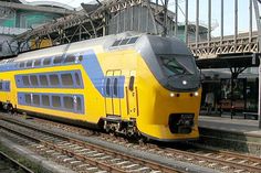 a yellow and blue train is on the tracks