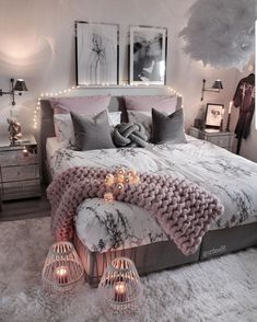 a bed with pillows and blankets on top of it in a room filled with lights