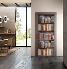 a room with a book shelf filled with lots of books next to a dining table