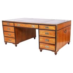 an antique wooden desk with glass top and drawers on casteors, from the early 20th century