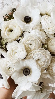 a woman holding a bouquet of white flowers