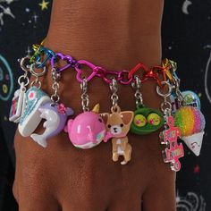 a close up of a person's hand wearing a bracelet with charms on it