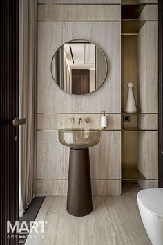 a bathroom sink sitting under a round mirror