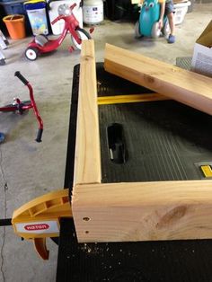 a piece of wood is being worked on by a person in a garage with other tools