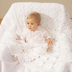 a baby is laying in a crocheted blanket