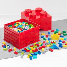 two red containers filled with legos on top of a gray surface next to each other