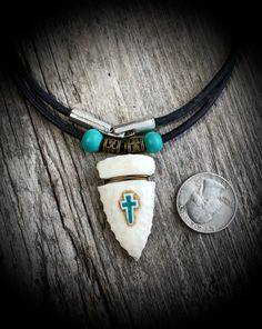 "You are considering an arrowhead that I hand carved from a piece of whitetail antler. I relief carved a Cross and then inlaid crushed turquoise into it. Beautiful detail! It is hand-knapped it to give it the appearance of a genuine arrowhead. The whole piece was sealed with a quality clear enamel. I think it turned out quite nice! It is strung on a 24\" 3mm round leather cord with an easy snap lock closure. Please let me know if you would like the cord to be a different length. VERY NICE with a Southwestern Arrowhead Jewelry Gift, Southwestern Style Arrowhead Jewelry Gift, Handmade Rustic White Jewelry, White Rustic Handmade Jewelry, Rustic Handmade White Jewelry, Rustic White Handmade Jewelry, Artisan White Turquoise Necklace As A Gift, Southwestern Style White Turquoise Necklace Gift, Southwestern White Turquoise Necklace Gift