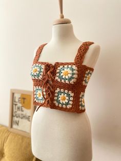 a crocheted top on a mannequin with flowers in the front and back