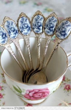 six antique blue and white spoons sitting in a cup