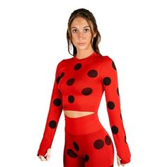 a woman in a red and black polka dot outfit with her hands on her hips