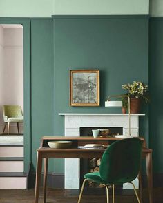 a green chair sits in front of a table with a potted plant on it