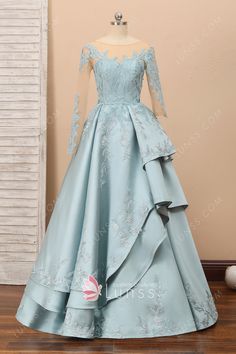 This vintage inspired unique ice blue prom dress features button back zipper closure bodice with chic illusion asymmetric length sleeves. The layered satin skirt adds fun element. Lace applique flows over this formal gown for a beautiful look. Lace Engagement Dress, Lunss Dresses, Layered Prom Dress, Satin Formal Gown, Fancy Gown, Kids Frock, Engagement Gowns, Matric Dance, Maxi Design