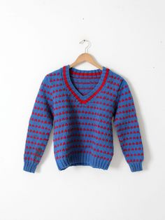 "This is a vintage hand-knit sweater.  Red dots line the cerulean blue thick knit sweater.  It has a v-neck line and ribbed cuffs and waist. Most likely wool or wool blend. CONDITION In fair to good condition with wear consistent with age and use.  Some dark spots on the sleeve and waistband.  Approximate Fit:  S / M MEASUREMENTS Bust:  38\"  ..  96.5 cm Length:  22.5\"  ..  57.2 cm Shoulders:  16.5\"  ..  41.9 cm Outside Sleeve:  22\"  ..  55.9 cm 92297" Wool V-neck Chunky Knit Sweater, Hand Knitted V-neck Winter Sweater, Hand Knitted V-neck Sweater For Winter, Thick Knit Sweater, Wool Knit Sweater, Cerulean Blue, Vintage Hippie, Plaid Coat, Hand Knitted Sweaters