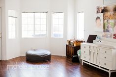 a living room with white walls and wood flooring has a round bean bag chair in the corner