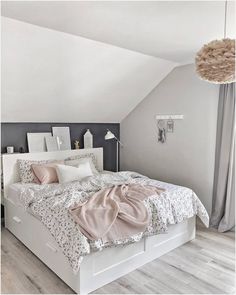 a white bed sitting in a bedroom next to a window