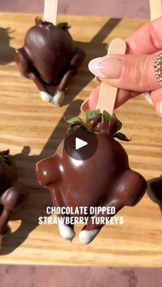 chocolate dipped strawberries in the shape of cows are being held by someone's hand