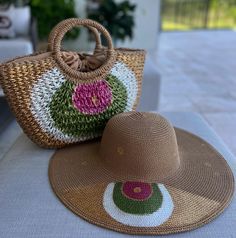 a straw hat sitting on top of a table next to a purse