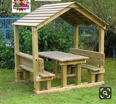 a wooden picnic table and bench in the grass