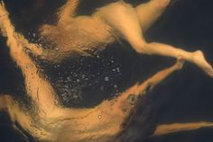 a woman floating in the water with her arms outstretched and legs spread out to side