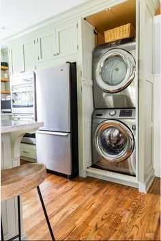 a washer and dryer in a small space with wood flooring on the side