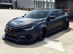 a black sports car parked in front of a building with an arrow on the side