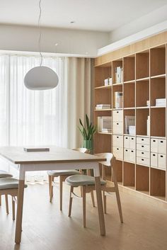 a dining room table and chairs in front of a bookshelf