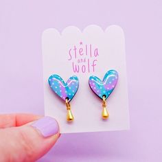 This version of the wonky heart drop earring has been hand painted in a modern abstract design using pretty pastel colours of emerald green, turquoise and pink with pale pink polka dots.  To finish the look a cute gold plated tear drop hangs from the bottom of the heart.  A coating of resin has been applied to give a high shine finish  The hearts are backed with gold plated posts and butterflies as standard.  These can be upgraded to Stirling silver or gold filled on request for an extra charge. Whimsical Multicolor Heart Earrings, Playful Handmade Heart Earrings, Playful Blue Heart-shaped Jewelry, Playful Handmade Heart-shaped Jewelry, Playful Pink Hand Painted Jewelry, Playful Hand Painted Pink Jewelry, Playful Pink Hand-painted Jewelry, Pastel Drop Earrings Jewelry As Gift, Whimsical Green Heart-shaped Jewelry