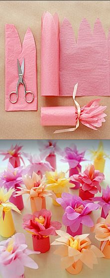 pink and yellow paper flowers are on the table next to some crafting supplies with scissors