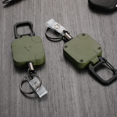 two green and black keychains sitting on top of a wooden table