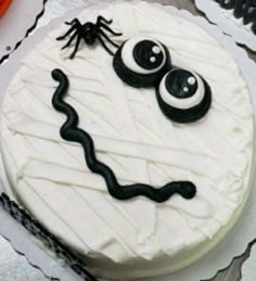 there is a cake decorated to look like a face with eyes and a spider on it