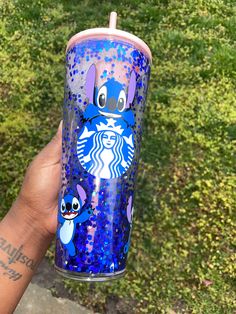 someone is holding up a starbucks cup with stitching on it and the lid has been painted