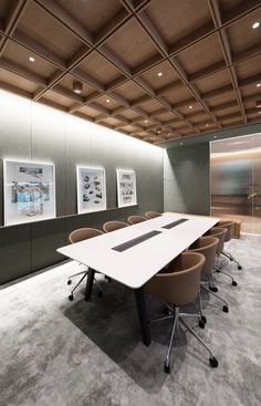 an empty conference room with chairs and pictures on the wall