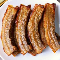 four pieces of cooked meat on a white plate