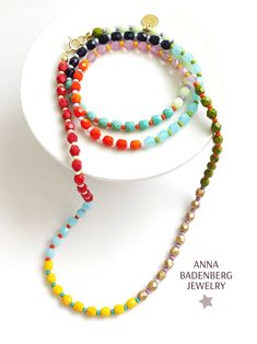 the multicolored beaded necklace is displayed on a white plate with a star charm