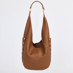 An updated version of everyone's favorite hobo bag has entered the chat; meet our updated Tom. With a zippered main compartment and adjustable strap, this shoulder bag still resembles the original, with pockets galore and a slouchy nature, making it extra roomy and the ultimate catch all bag. This leather features a soft pebbled texture with a hint of shine. Embrace the warm allure of this medium brown hue, enriched with a delicate yellow undertone that adds depth and sophistication to any ensemble. Crafted with a soft pebbled leather with a hint of shine featuring a warm medium brown hue Red logo twill lining Brushed gold hardware, functionality covered for life Exterior: side panels, crisscross drop pockets on front and back panels, adjustable shoulder strap with large O ring, slit detai Luxury Shoulder Bag With Snap Closure For On-the-go, Everyday Use Bucket Shoulder Bag With Gold-tone Hardware, Gold-tone Bucket Shoulder Bag For Daily Use, Classic Hobo Bag With Snap Closure For Everyday, Leather Bucket Hobo Bag With Snap Closure, Everyday Hobo Bag With Gold-tone Hardware And Double Handle, Everyday Brown Hobo Bag With Gold-tone Hardware, Bucket Hobo Bag With Gold-tone Hardware For Everyday Use, Versatile Hobo Bag Tote With Gold-tone Hardware