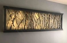 a metal wall art with lights on it in a room next to a bed and window