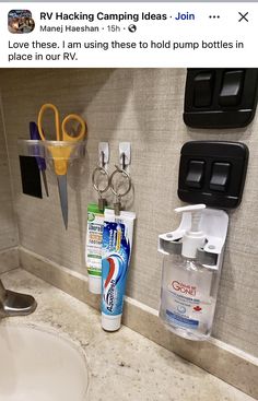 a bathroom sink with toothpaste, mouthwash and other items hanging on the wall