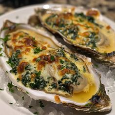 two oysters with cheese and spinach are on the plate, ready to be eaten