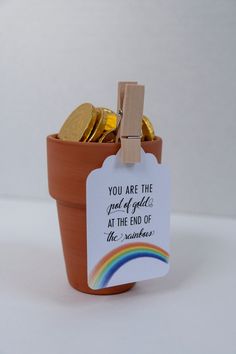 a small pot filled with gold coins and a tag that says you are the good god at the end of the rainbow