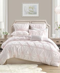 a bed with white comforter and pillows in a room