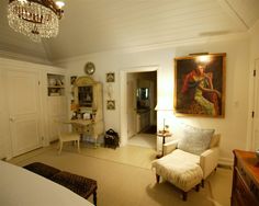 a living room with white furniture and a chandelier hanging from the ceiling above it