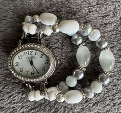 This white and gray beaded interchangeable stretch bracelet is accented with silver spacers and beads.  It is attached to a small, oval watch face surrounded by rhinestones. ladies watch band sizing:  simply measure your wrist snuggly with a string or ribbon.  Order your size (small, med, large) according to your measurement.   beads may vary slightly due to availability and desired watch size. Oval Watch, Round Watch, Grey Beads, White Watch, Watch Fashion, Watch Bracelet, Stretch Bands, Watch Faces, Women Wrist Watch