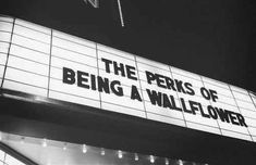 a sign that says the perks of being a wallflower hanging from a building