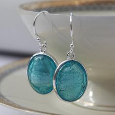 Blue Earrings, Gift for Her, Murano Glass Earrings, Turquoise Jewelry, Something Blue, Blue Wedding, best friend gift, 40th birthday gift_________________________________________These sterling silver oval blue earrings feature a piece of oval Murano glass containing white gold, handset in a sterling silver frame setting by British jewellery designer Claudette Worters.These Murano glass earrings would make a fabulous gift for a bride as her Something Blue or worn at a themed blue wedding.These bl Turquoise Oval Earrings For Anniversary, Oval Turquoise Earrings For Anniversary, Blue Oval Nickel-free Earrings, Blue Nickel-free Earrings For Anniversary, Nickel-free Blue Earrings For Anniversary, Nickel-free Blue Earrings As Gift For Her, Silver Oval Pendant Earrings For Anniversary, Nickel Free Blue Earrings As Gift For Her, Oval Pendant Jewelry Set For Anniversary