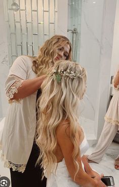 a woman is getting her hair done in front of a mirror