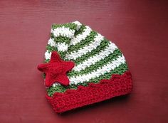 a crocheted hat with a red star on the front and green stripes on the back