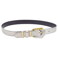 Gianni Versace thin waist belt from the early 1990s. Silver rigid leather with gold tone hardware. Gold on buckle features Greek key detailing. Belt loops are gold tone metal with a silver leather in between. Tonal silver top stitching. Black leather interior with contrasting gold brand stamp. Excellent vintage condition. Marked 30"/75cm, 1" wide. Made in Italy. Brand Stamp, Silver Top, Gold Belt, Gold Belts, Silver Tops, Gold Branding, Greek Key, Gianni Versace, Leather Interior