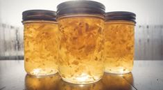 three jars filled with liquid sitting on top of a table