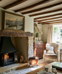 a living room filled with furniture and a fire place in front of a painting on the wall